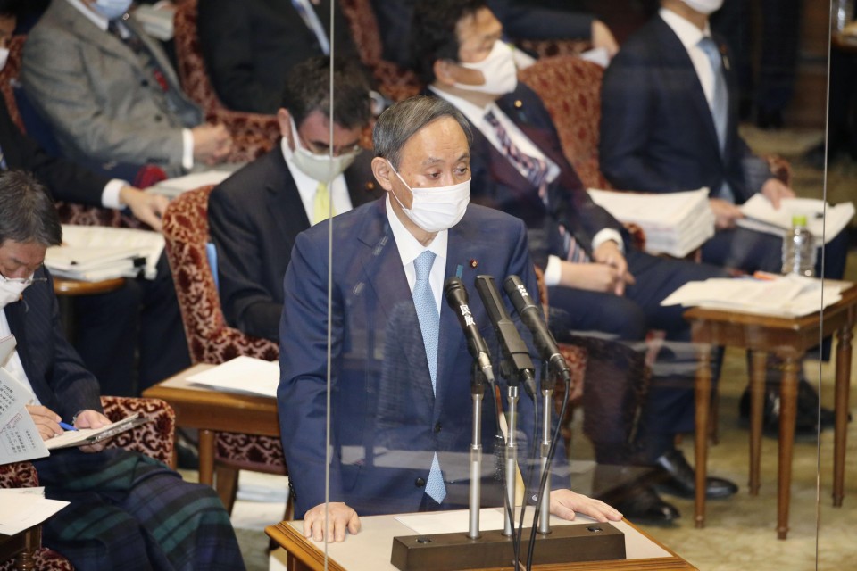 日本首相菅义伟1月27日在东京举行的参议院预算委员会会议上发表讲话，在他面前摆放着透明的丙烯酸屏幕，以防止冠状病毒感染。（图片来源：共同社）.jpg